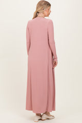 woman wearing a long pink ribbed dress viewed from the back