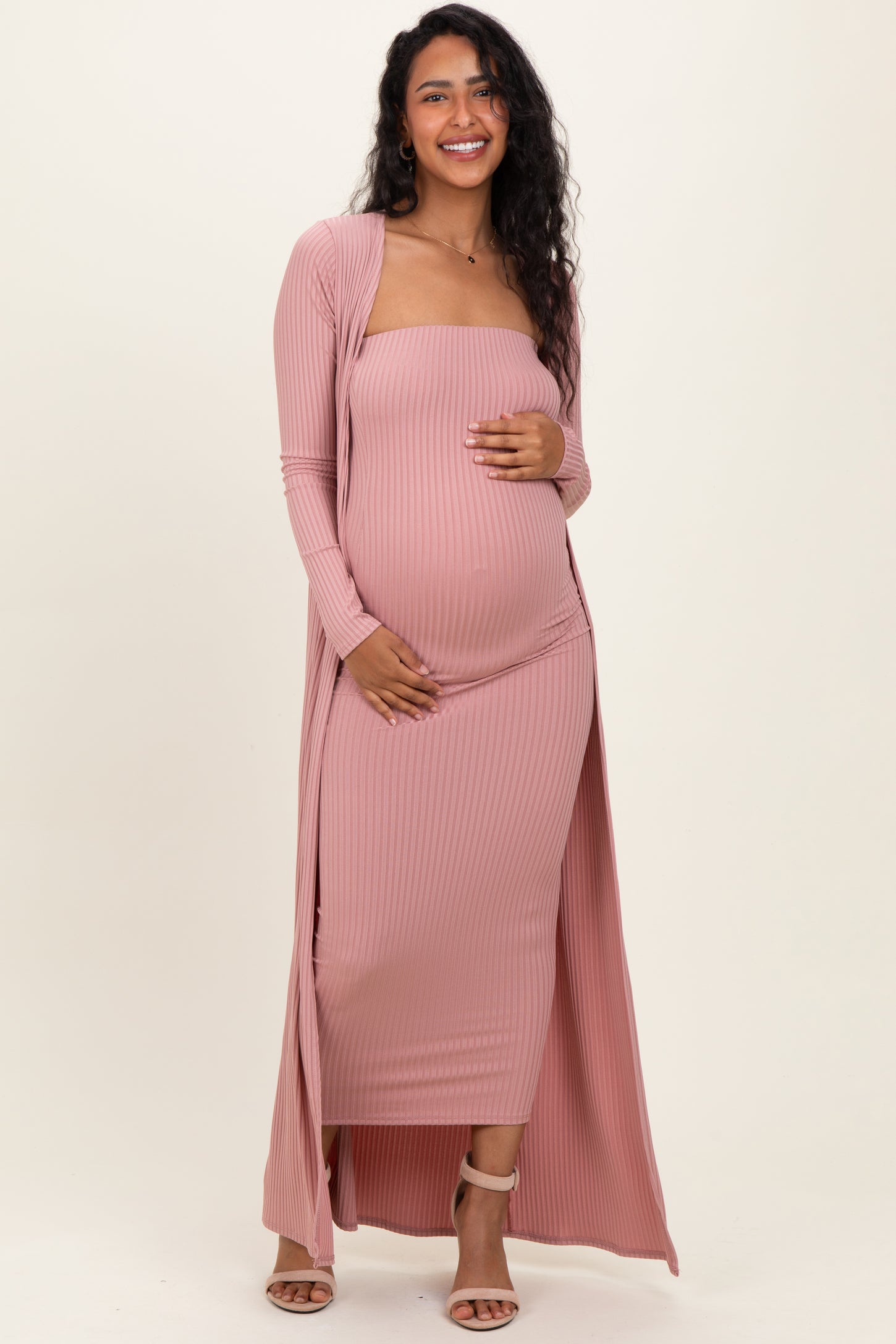 woman wearing a pink ribbed maternity maxi dress with a long cardigan, showcasing her baby bump