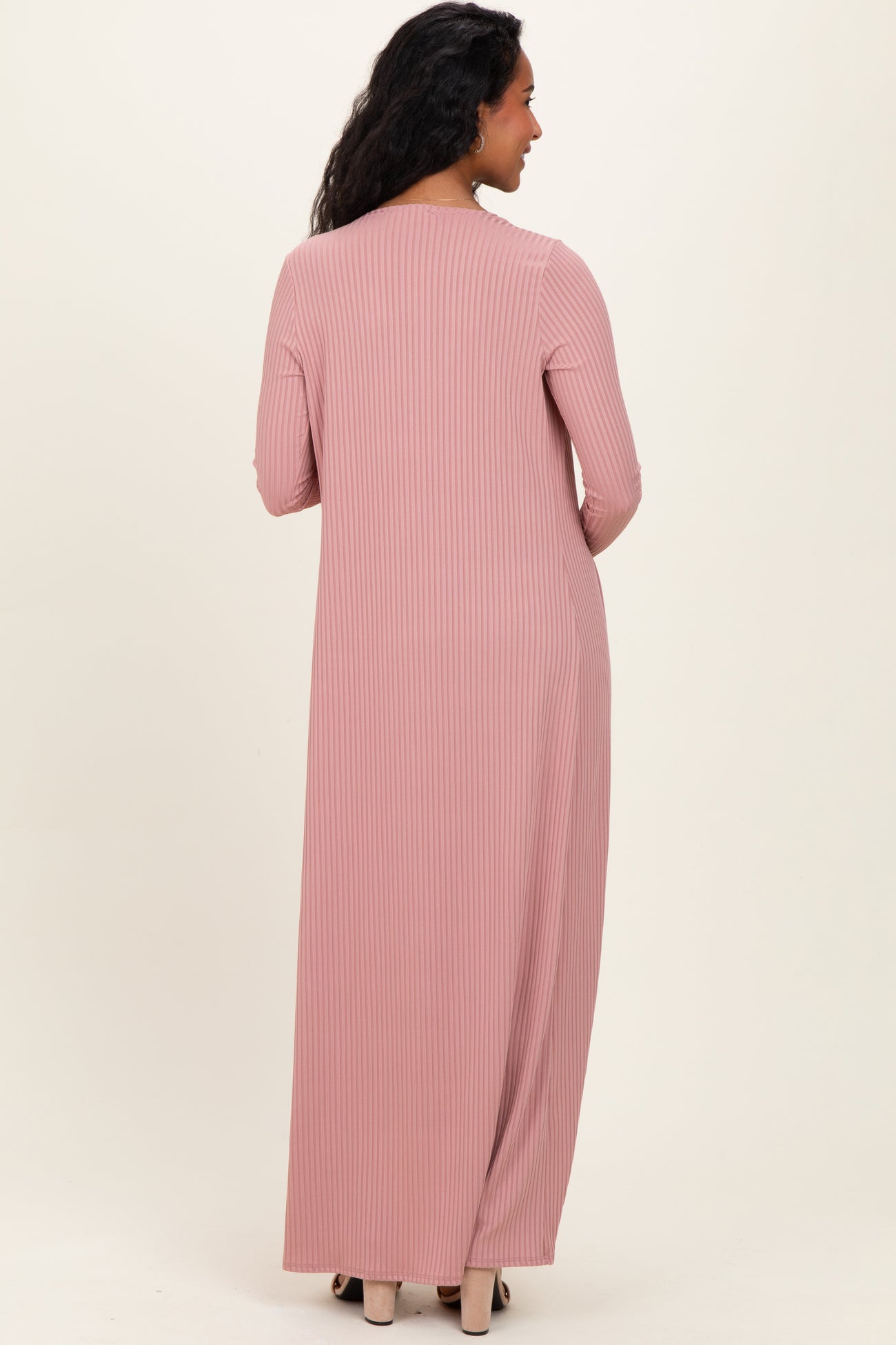 woman wearing a long pink ribbed maternity dress, showing the back view with long sleeves