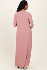 woman wearing a long pink ribbed maternity dress, showing the back view with long sleeves