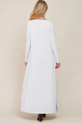woman wearing a long sleeve light gray maternity maxi dress with vertical stripes, viewed from the back