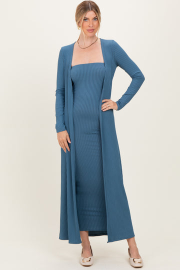 woman wearing a blue ribbed two-piece dress with a fitted bodice and long cardigan sleeves