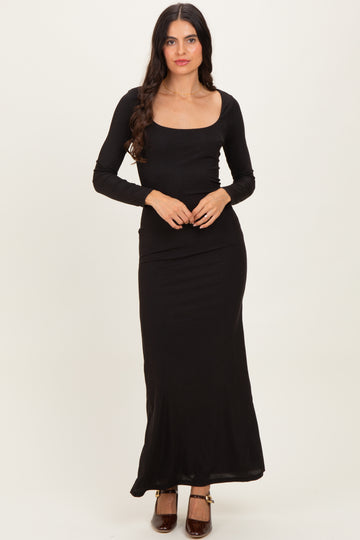 woman wearing a black long sleeve maxi dress with a square neckline and fitted silhouette