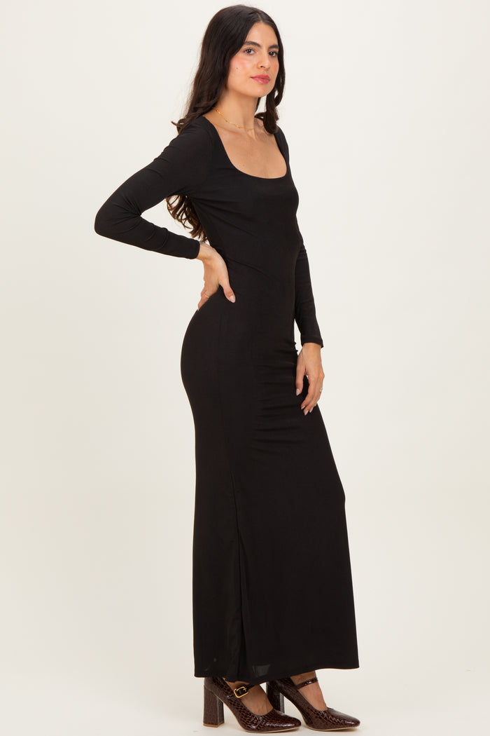 woman wearing a black long sleeve maxi dress with a scoop neckline and side slit