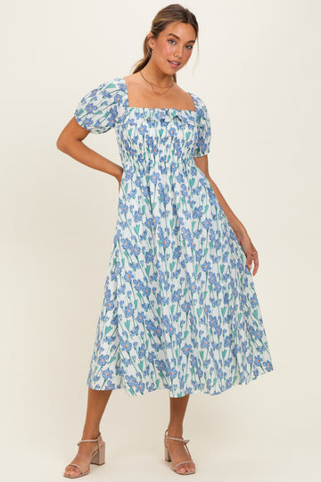 woman wearing a blue and white floral midi dress with puff sleeves and a square neckline