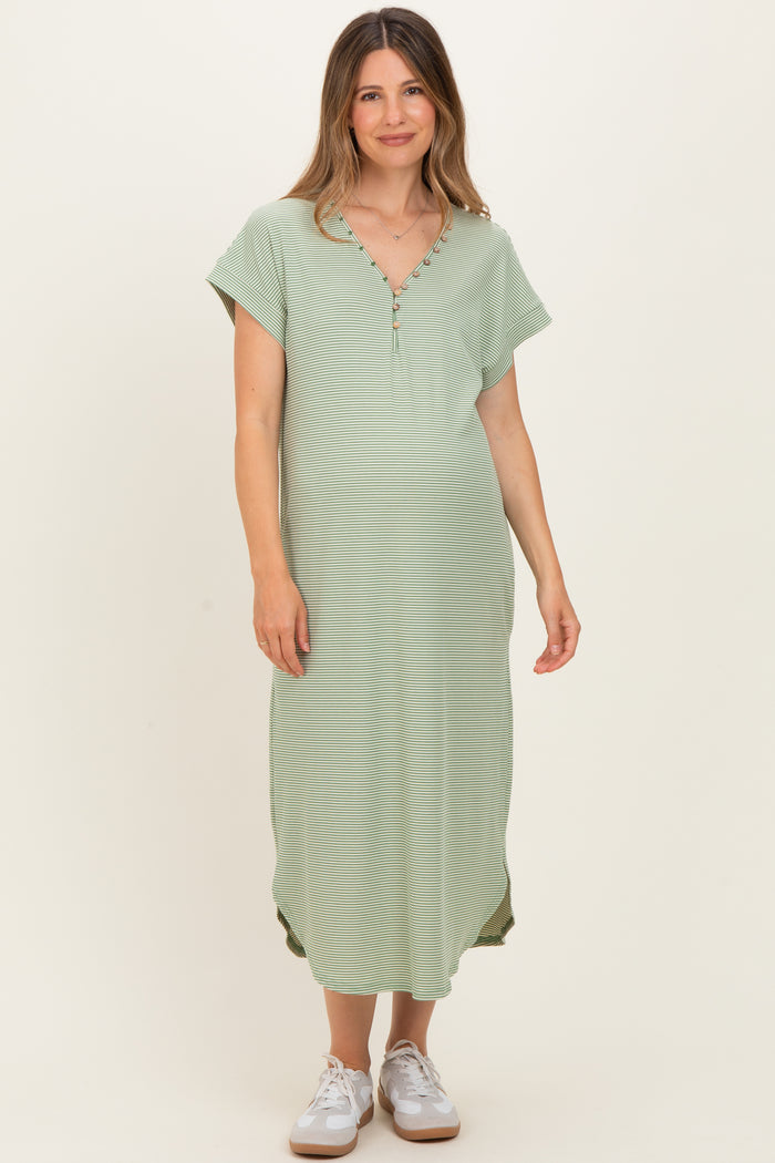 woman wearing a green maternity maxi dress with short sleeves and buttons at the neckline, showing a baby bump