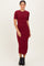 woman wearing a burgundy short sleeve midi dress with side slits and a fitted silhouette