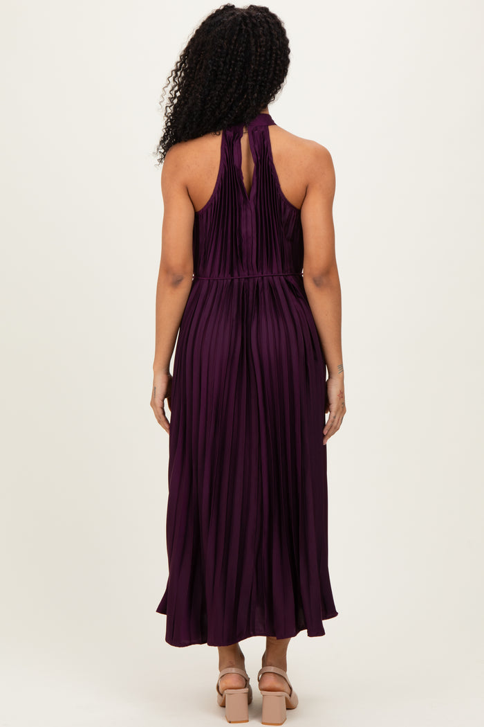 woman wearing a purple pleated halter neck maxi dress, showing the back view with a keyhole detail and flowy hem