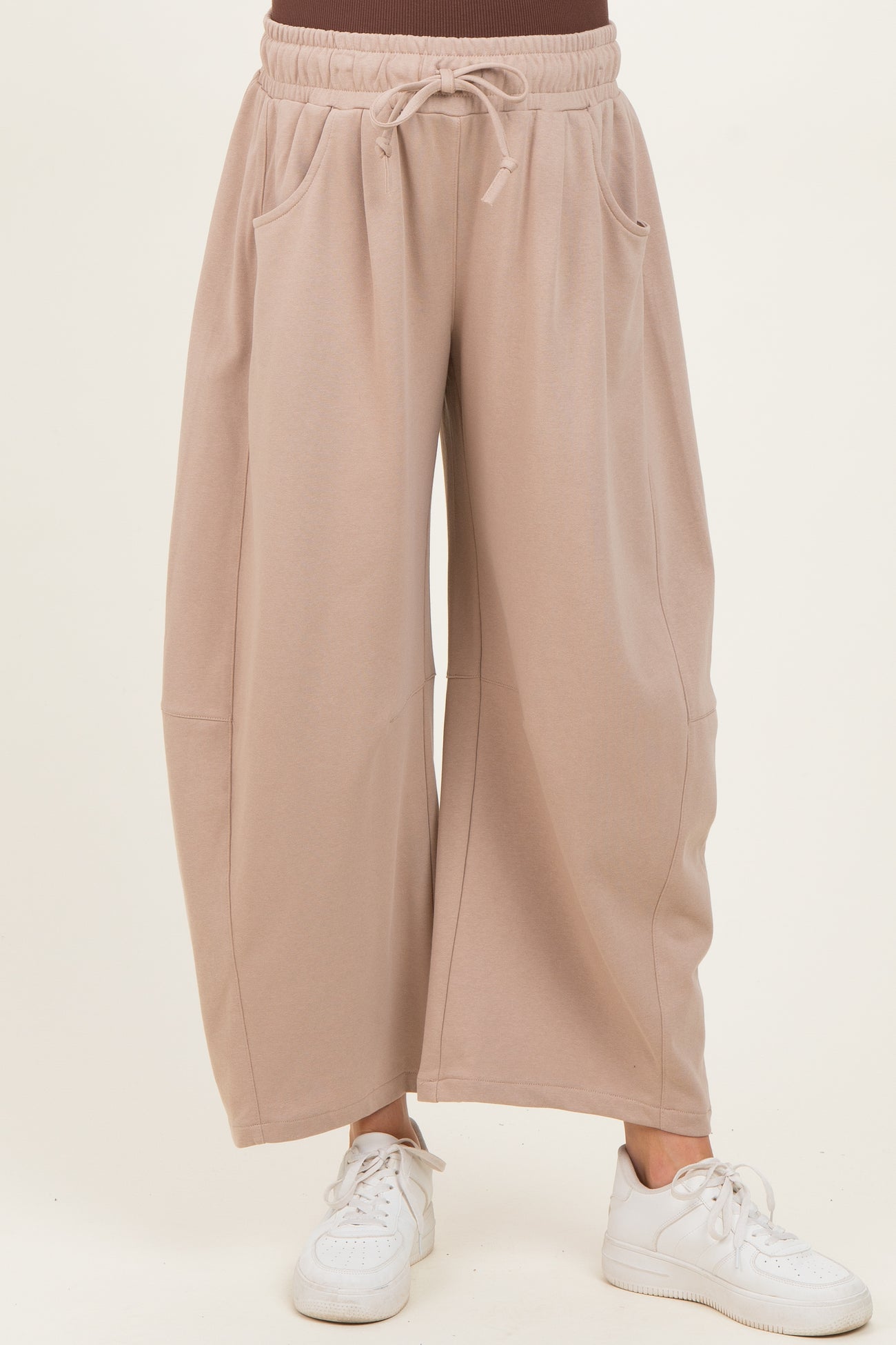 woman wearing beige wide-leg maternity pants with pockets and an elastic waistband