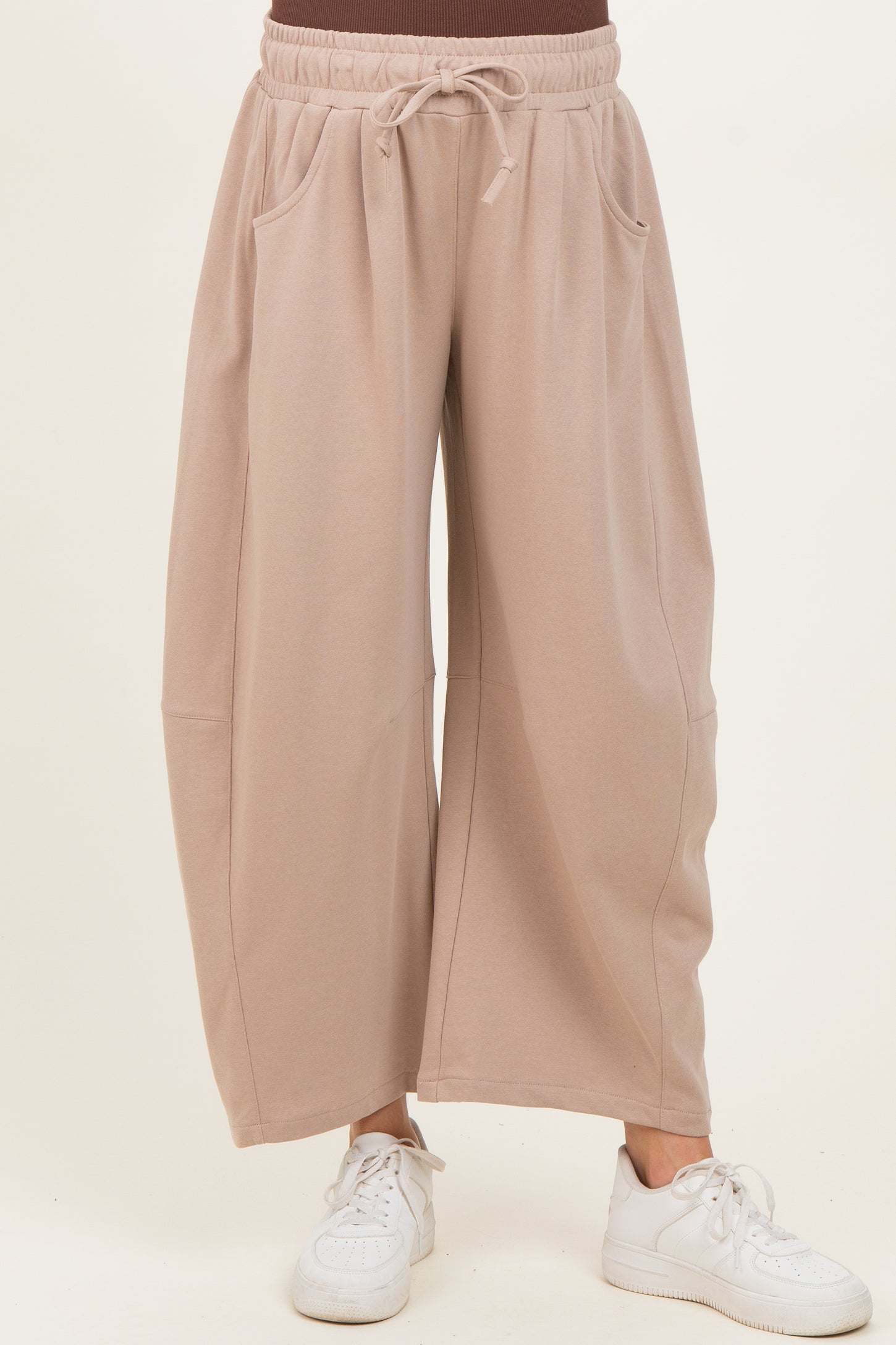 woman wearing beige wide-leg maternity pants with pockets and an elastic waistband