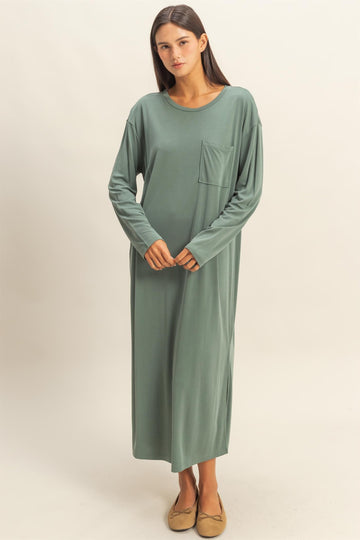 woman wearing a long sage green maxi dress with long sleeves and a chest pocket