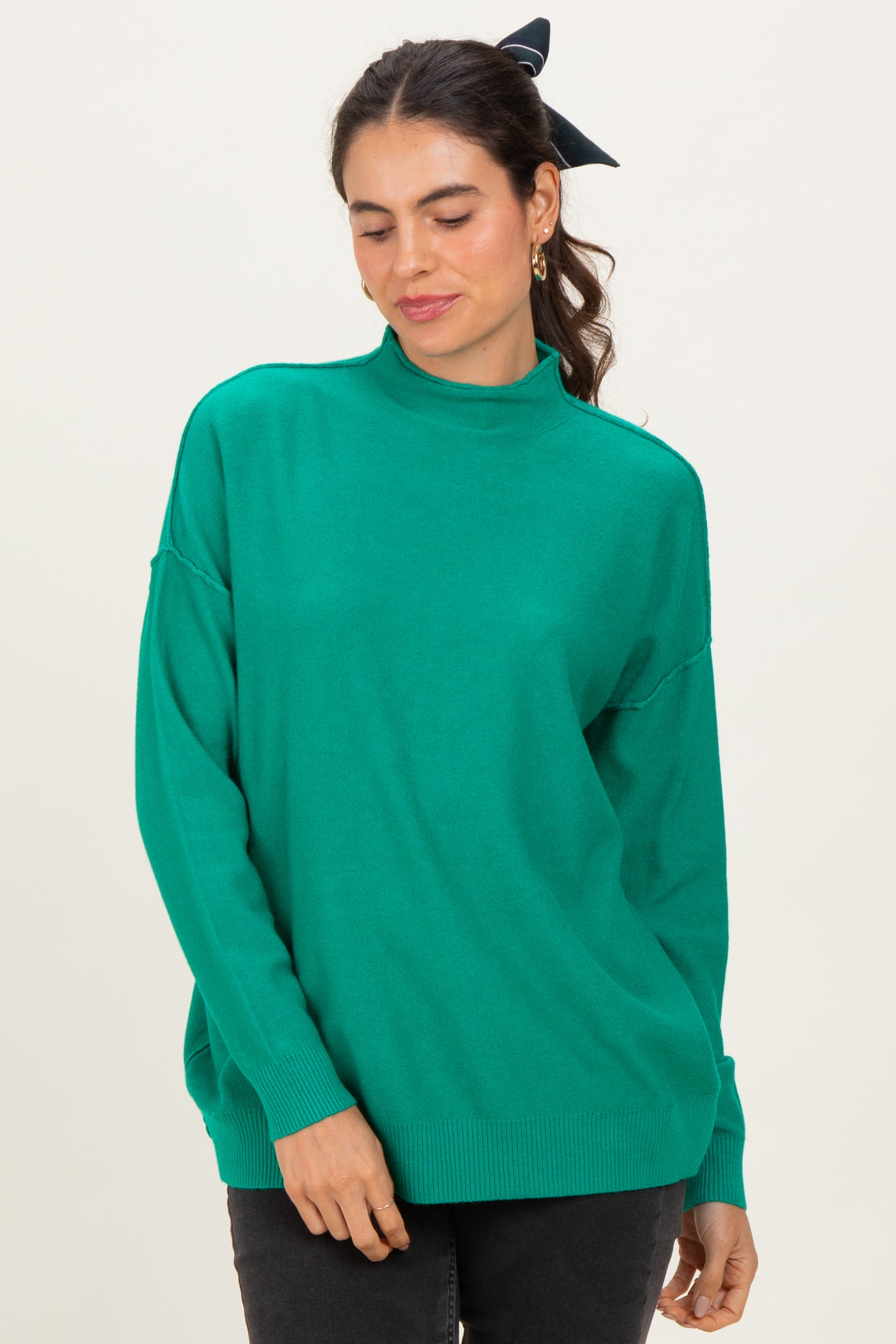 woman wearing a bright green oversized turtleneck sweater with long sleeves and relaxed fit