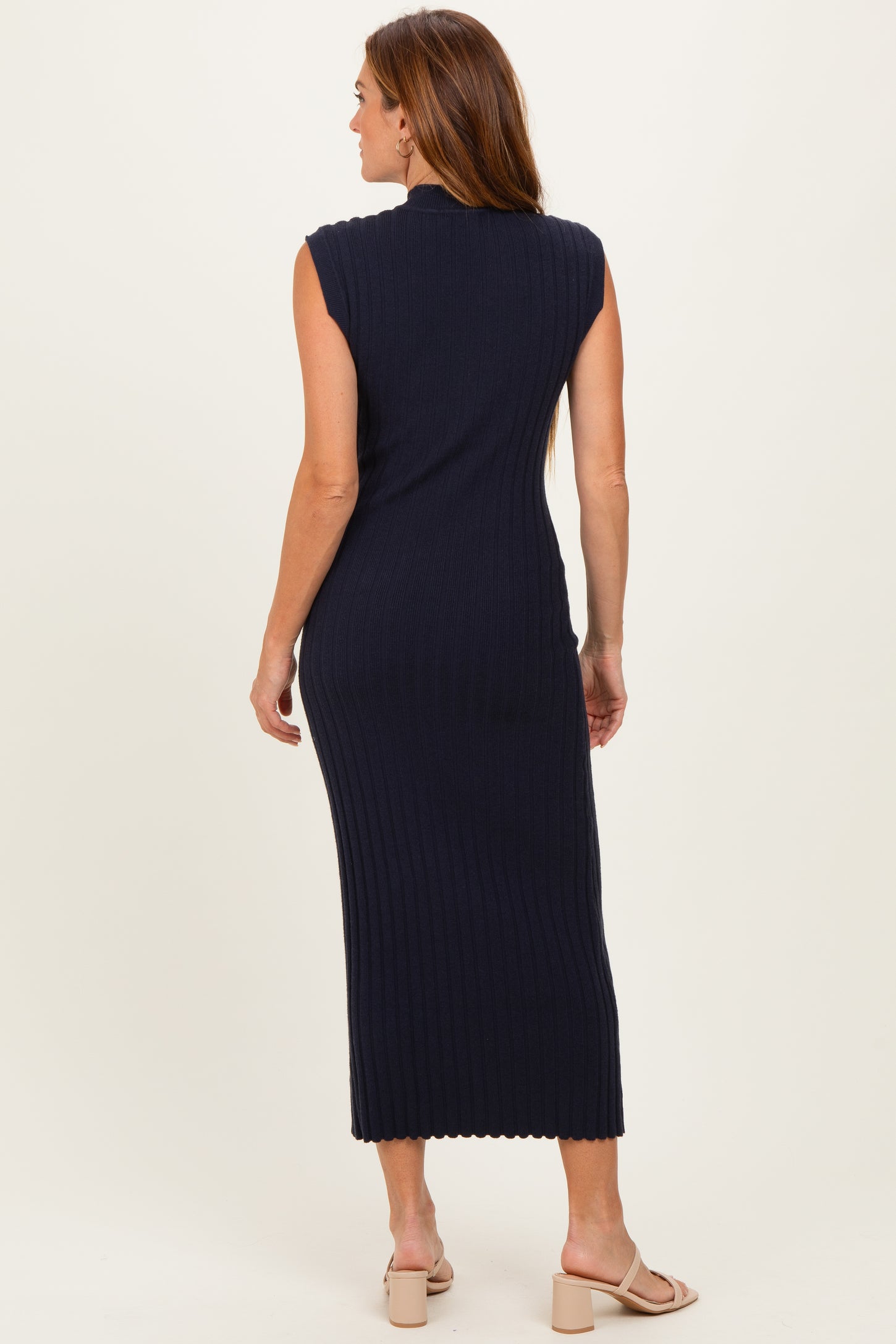 woman wearing a navy ribbed sleeveless midi dress with a fitted silhouette and scalloped neckline