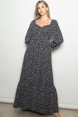 woman wearing a navy floral long sleeve maxi dress with a square neckline and button details