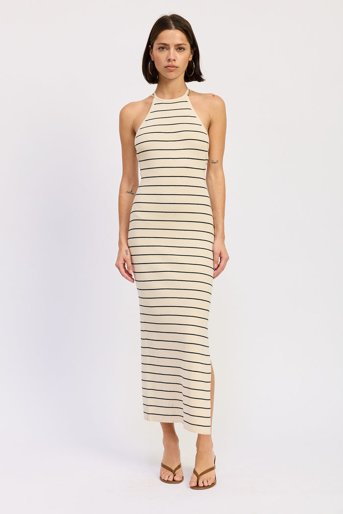 woman wearing a beige striped halter neck maxi dress with side slits