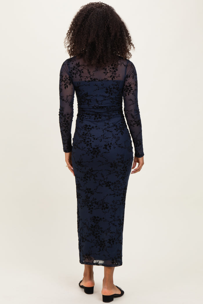woman wearing a navy blue long sleeve floral lace dress with a fitted silhouette and a floor-length hem