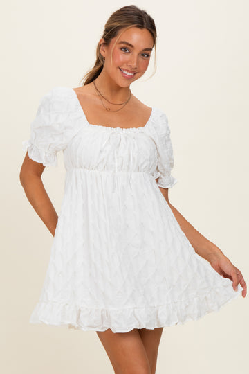 woman wearing a white puff sleeve mini dress with a square neckline and ruffle hem