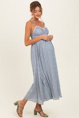 woman wearing a light blue floral maternity maxi dress with adjustable straps and a baby bump visible