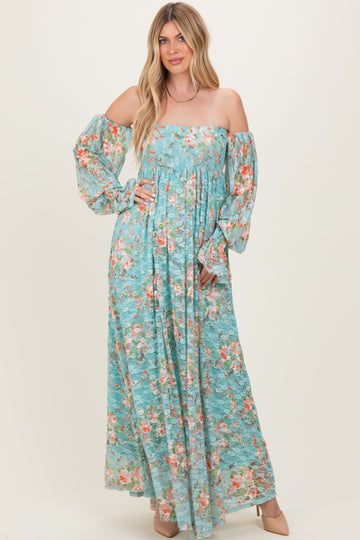 woman wearing a blue floral maxi dress with off-the-shoulder sleeves and a fitted bodice