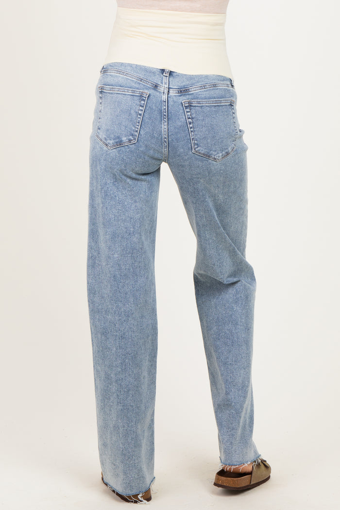 woman wearing light blue maternity jeans with a relaxed fit and back view showing subtle distressing at the hem