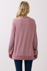 woman wearing a striped mauve long sleeve sweatshirt, view from the back, paired with dark blue jeans