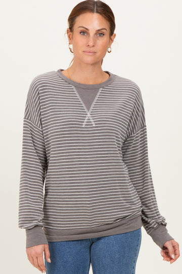 woman wearing a gray striped long sleeve sweatshirt with a relaxed fit and ribbed cuffs