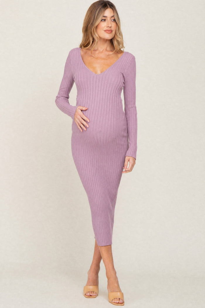 woman wearing a dusty rose long sleeve ribbed maternity dress and holding her baby bump