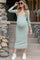 woman wearing a green ribbed midi maternity dress with a v-neck and long sleeves, showcasing her baby bump