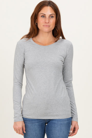 woman wearing a light grey long sleeve t-shirt paired with blue jeans