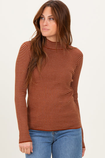 woman wearing a rust striped long sleeve top with a mock neck and paired with blue jeans