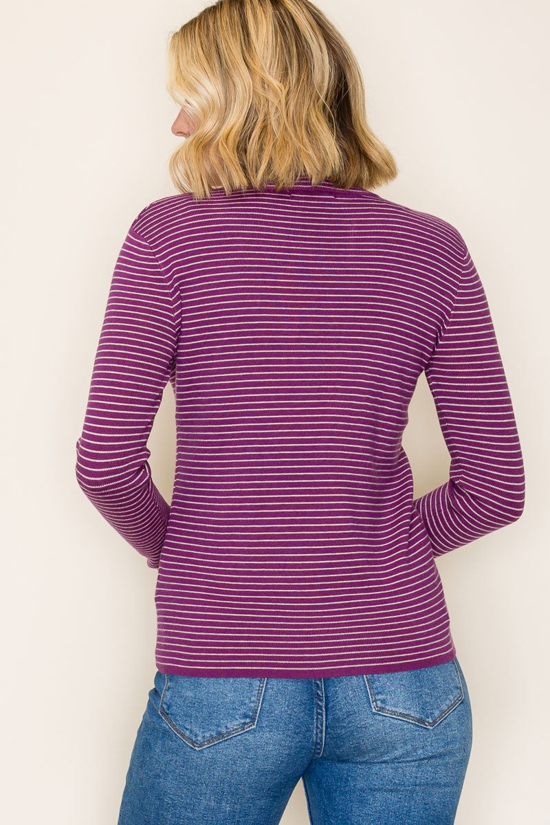 woman wearing a purple and white striped long sleeve top, seen from the back with light blue jeans