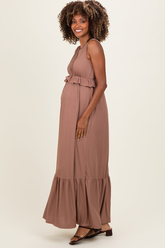 woman wearing a brown striped maternity maxi dress with a ruffle waist and a visible baby bump