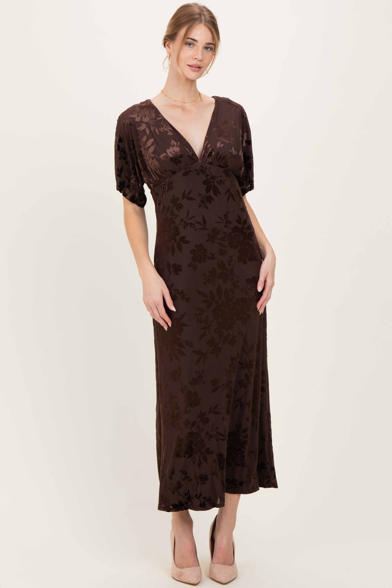 woman wearing a brown floral print maxi dress with short puff sleeves and a deep v-neckline