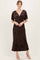 woman wearing a dark brown floral print maxi dress with short sleeves and a deep V neckline