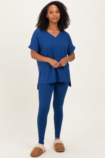 woman wearing a blue short sleeve v-neck top and matching blue leggings, styled with cozy slippers