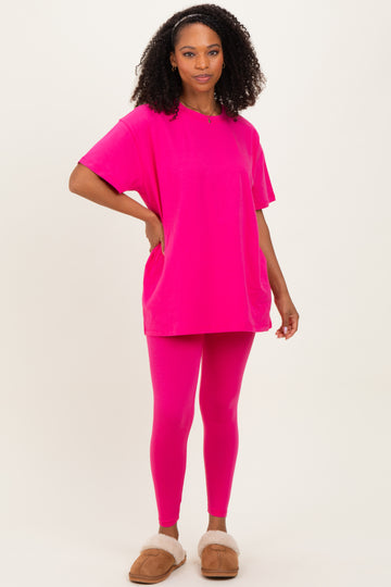 woman wearing a vibrant pink oversized t-shirt and matching pink leggings with fluffy slippers