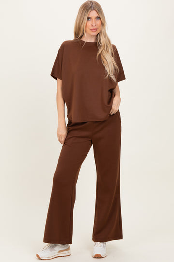 woman wearing a brown oversized t-shirt and matching wide-leg pants, styled with white sneakers