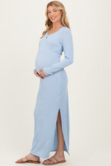 woman wearing a light blue ribbed maternity maxi dress with side slits and holding her baby bump