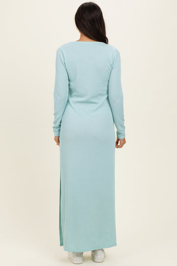 woman wearing a light blue ribbed maxi dress with long sleeves and a side slit, viewed from the back