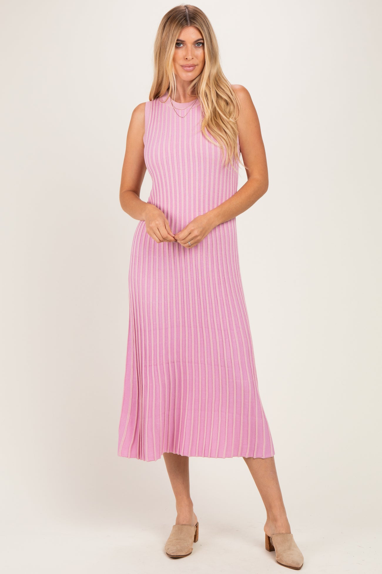 woman wearing a sleeveless pink ribbed midi dress with a flared hem and a relaxed fit