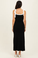 woman wearing a black maxi dress with white tie shoulder straps, seen from the back