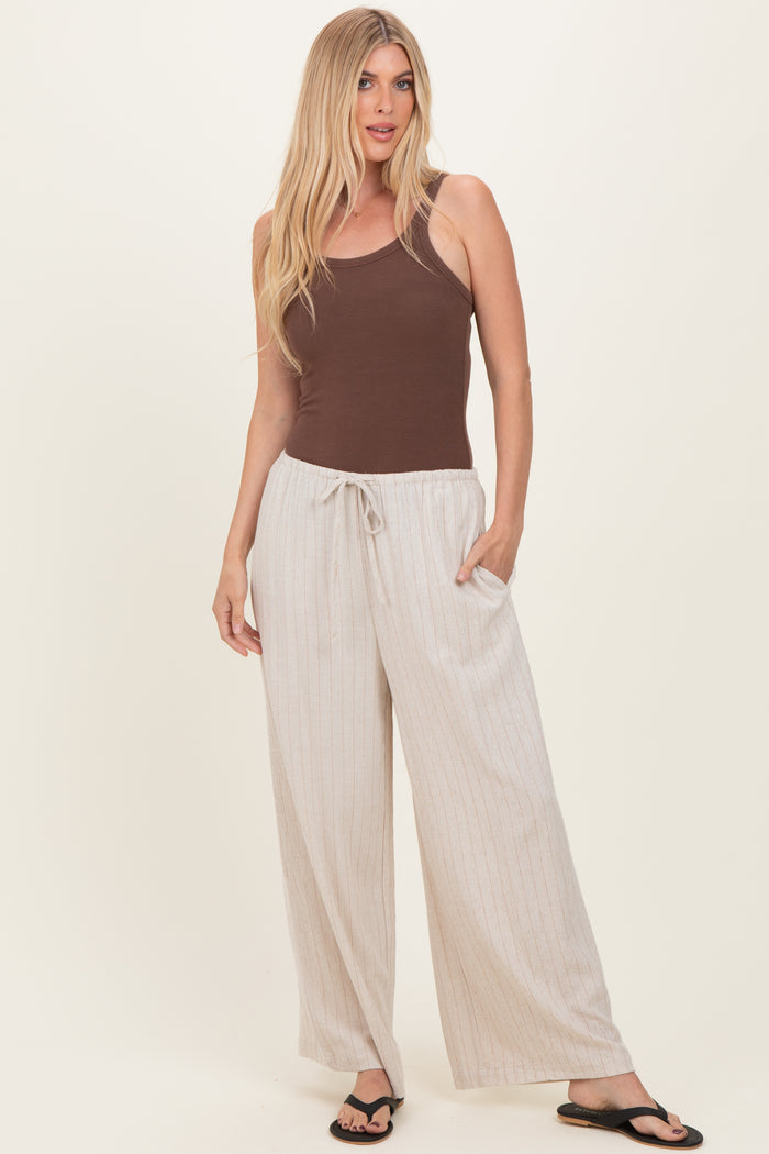 woman wearing a brown tank top and beige striped wide-leg pants with pockets and drawstring waist