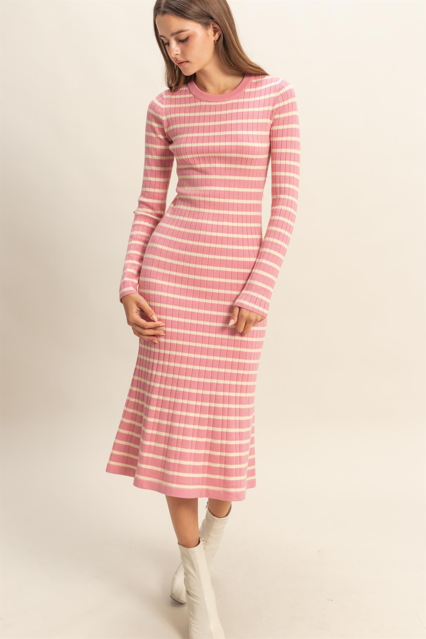 woman wearing a pink striped long sleeve midi dress with a flared hem and fitted bodice