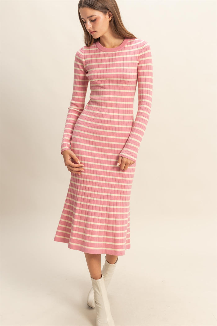 woman wearing a pink striped long sleeve midi dress with a flared hem and fitted bodice