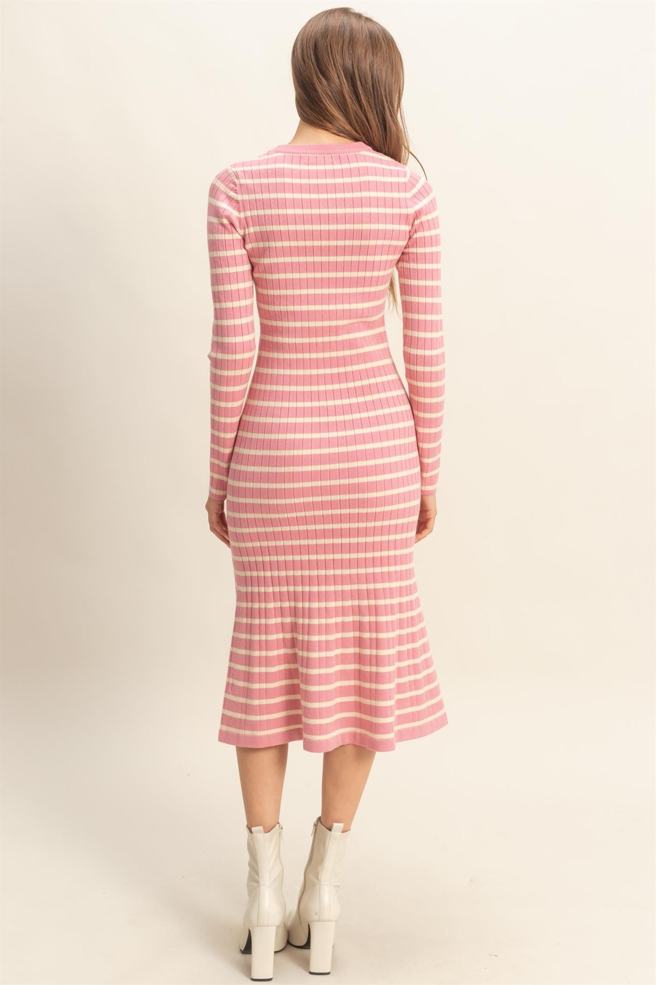 woman wearing a pink and white striped long sleeve ribbed dress with a flared hem and fitted silhouette