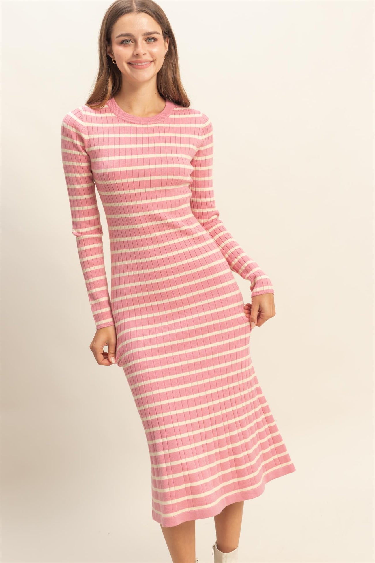 woman wearing a pink and white striped long sleeve midi dress with a fitted silhouette