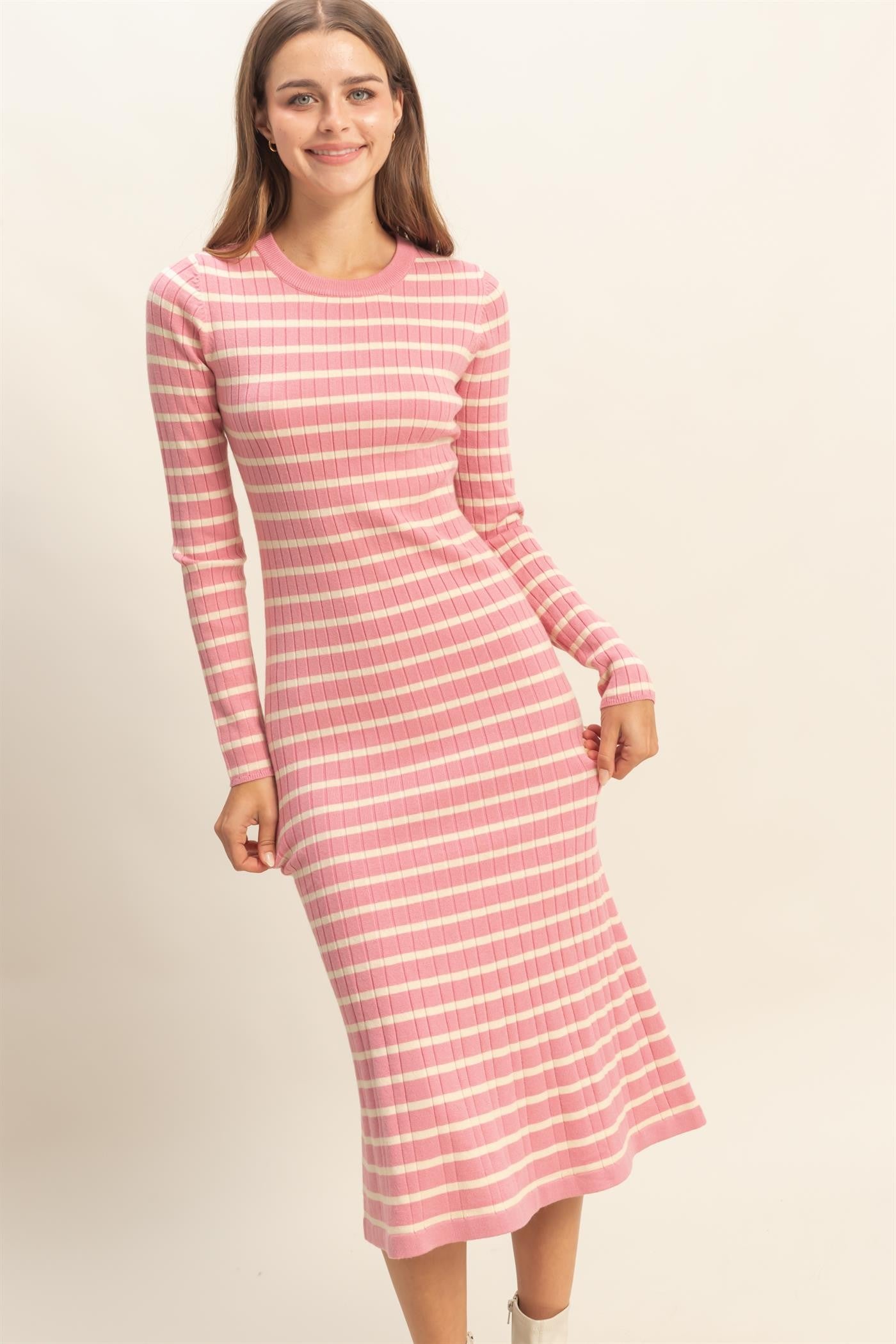 woman wearing a pink and white striped long sleeve midi dress with a fitted silhouette