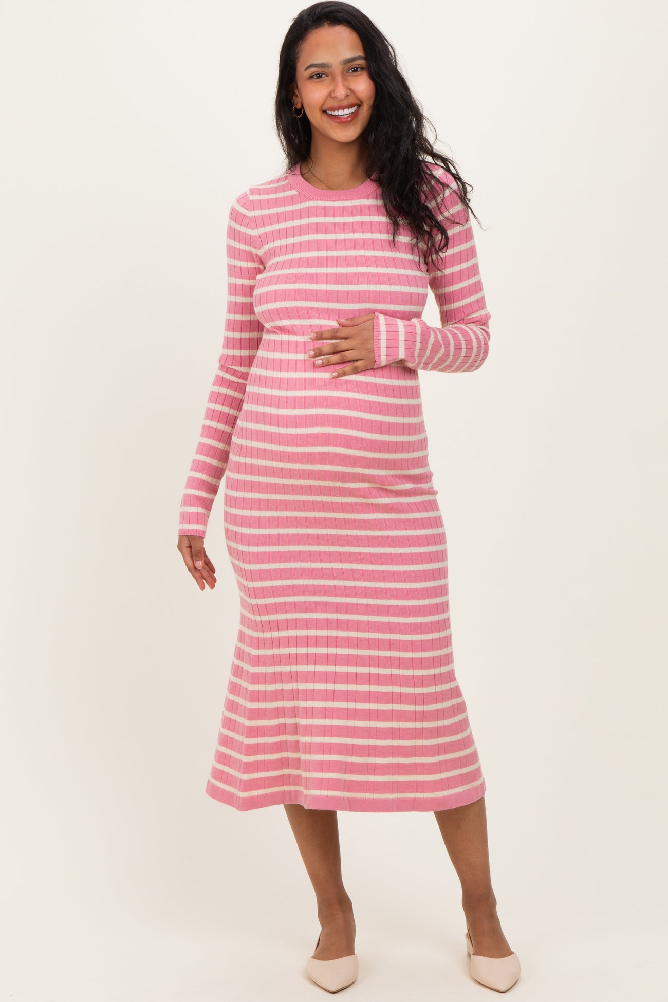 woman wearing a pink and white striped maternity dress and holding her baby bump