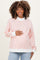 woman wearing a striped light pink maternity sweatshirt and holding her baby bump
