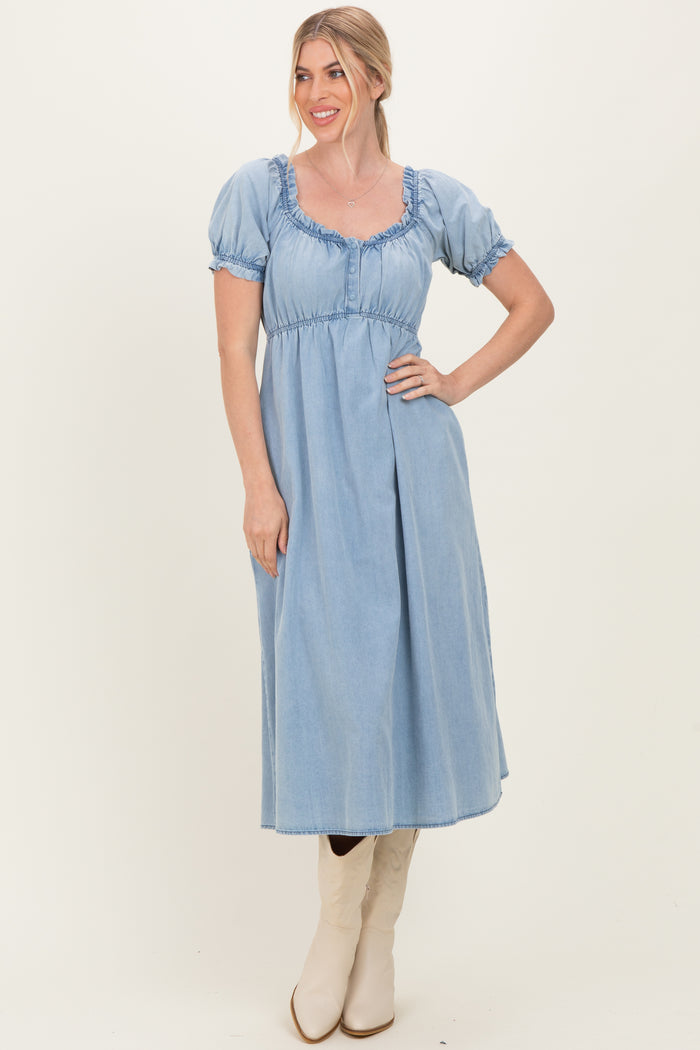 woman wearing a light blue denim midi dress with puff sleeves and a ruffled neckline, paired with beige cowboy boots